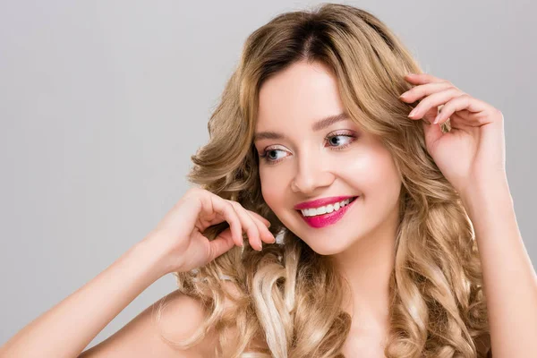 Tender nude smiling young woman touching hair isolated on grey — Stock Photo