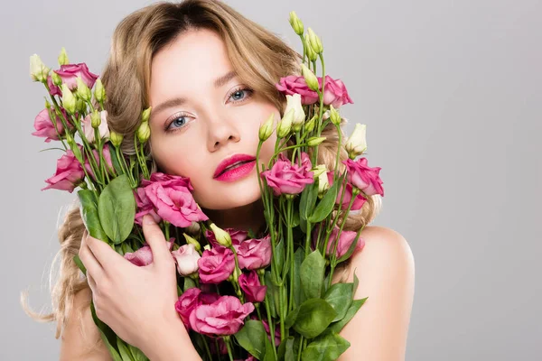 Nackt schöne Frühling junge Frau umarmt Strauß Eustoma-Blumen isoliert auf grau — Stockfoto