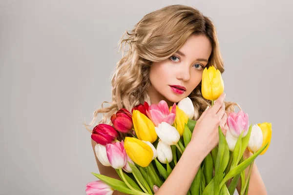 Junge nackte attraktive Frühling Frau hält Strauß von bunten Tulpen isoliert auf grau — Stockfoto