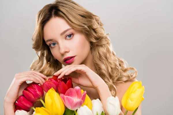 Junge nackte zarte attraktive Frühlingsfrau berührt Strauß von bunten Tulpen isoliert auf grau — Stockfoto