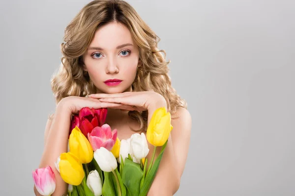 Joven mujer de primavera desnuda posando con ramo de tulipanes aislados en gris - foto de stock