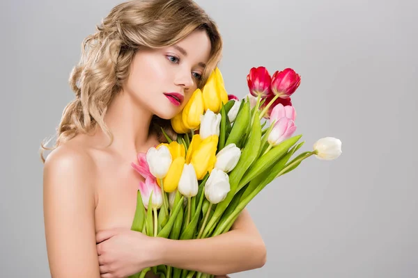 Молода красива гола весна жінка з тюльпанами ізольована на сірому — стокове фото