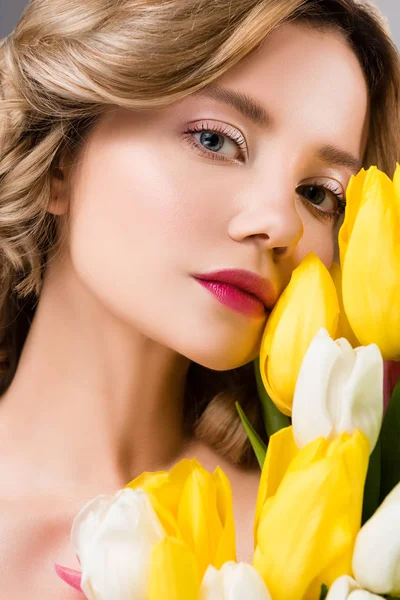 Jeune belle femme de printemps avec bouquet de tulipes jaunes — Photo de stock