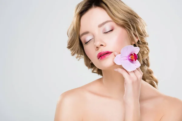 Ragazza con gli occhi chiusi tenendo fiore isolato su grigio — Foto stock