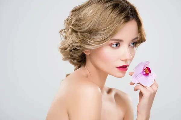 Attractive tender girl holding purple flower isolated on grey — Stock Photo