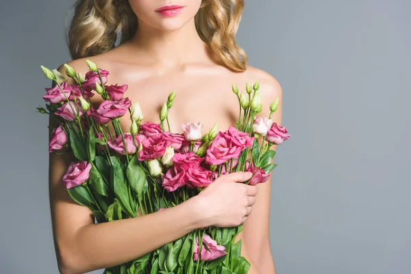 Vista ritagliata di donna nuda in possesso di bouquet di fiori di eustoma isolato su grigio — Foto stock