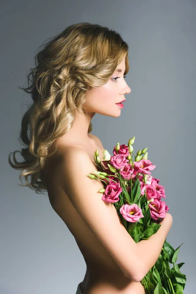 Vista lateral da menina nua segurando buquê de flores isoladas em cinza — Fotografia de Stock