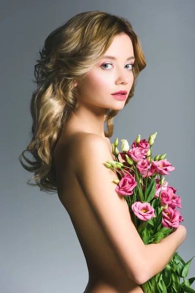 Bela menina nua segurando buquê de flores eustoma isolado em cinza — Fotografia de Stock