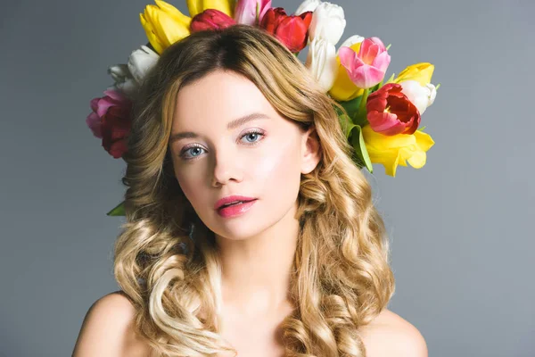 Bella donna con corona di fiori su capelli isolati su grigio — Foto stock