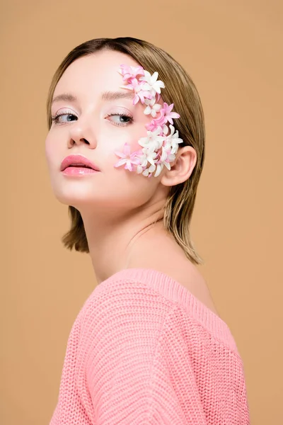 Ragazza premurosa con fiori sul viso isolato su beige — Foto stock