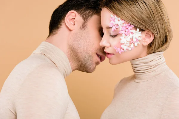 Homem macio beijando namorada bonita com os olhos fechados isolados no bege — Fotografia de Stock