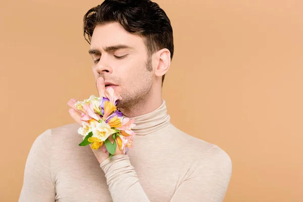 Mann mit Alstroemeria-Blüten an der Hand zeigt Schweigezeichen isoliert auf beige — Stockfoto