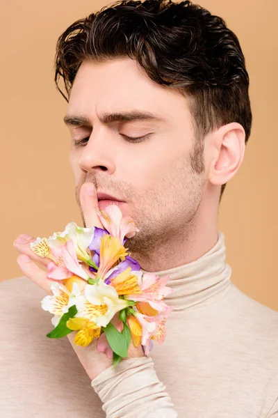 Handsome man with alstroemeria flowers on hand showing hush sign isolated on beige — Stock Photo