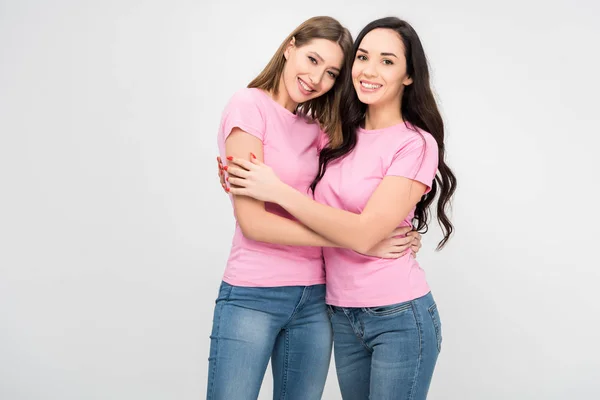 Cheerful girls standing and hugging isolated on grey — Stock Photo