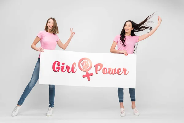 Mulheres alegres segurando grande sinal com letras poder menina no fundo cinza — Fotografia de Stock