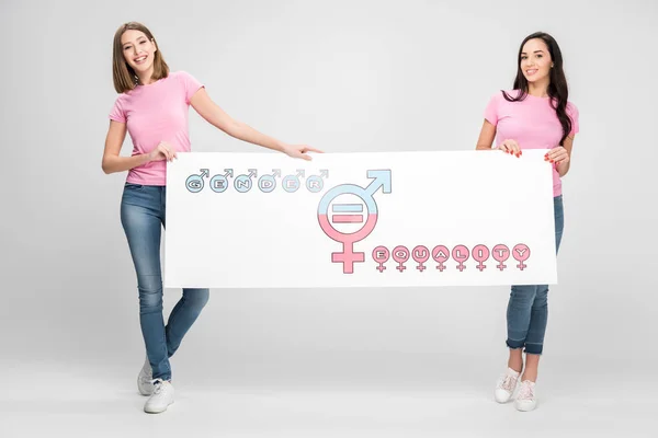 Cheerful women holding large sign with gender equality symbol on grey background — Stock Photo