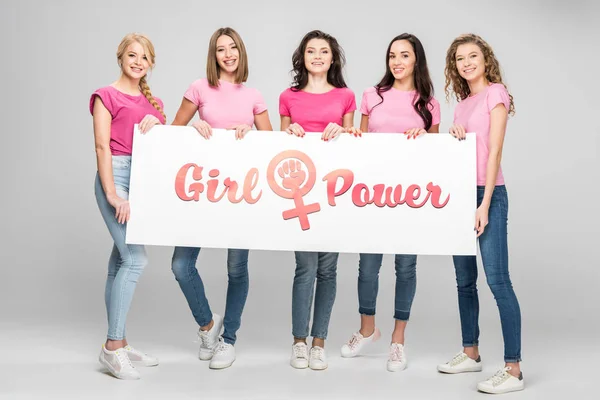 Schöne junge Frauen mit großem Schild mit Girl Power Schriftzug auf grauem Hintergrund — Stockfoto