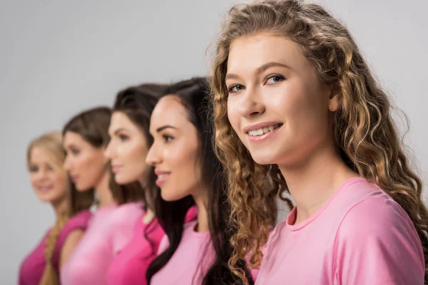 Selektiver Fokus des glücklichen Mädchens mit lockigem Haar in der Nähe junger Frauen isoliert auf grau — Stockfoto