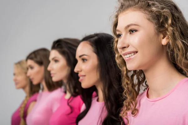 Selective focus of cheerful girl with curly hair near young women isolated on grey — Stock Photo