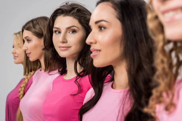 Selektiver Fokus attraktiver Mädchen, die in die Kamera schauen, in der Nähe schöner junger Frauen isoliert auf grau — Stockfoto