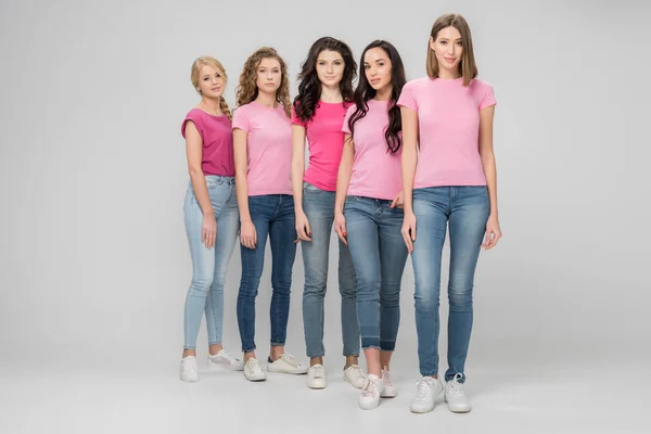 Beautiful young women standing together on grey background — Stock Photo