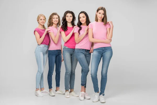 Jolies jeunes femmes debout ensemble sur fond gris — Photo de stock