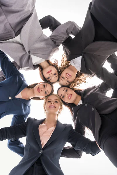 Bottom view of cheerful businesswomen hugging isolated on grey — Stock Photo