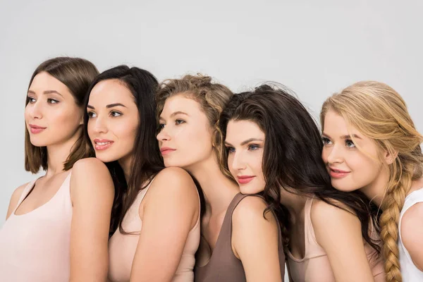 Досить молоді жінки, поклавши голів на плечах один від одного ізольовані на сірому — стокове фото