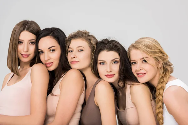 Pretty young friends putting heads on shoulders of each other isolated on grey — Stock Photo