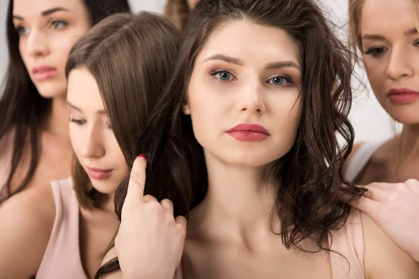 Close up of beautiful woman looking at camera near female friends standing together while support each other — Stock Photo