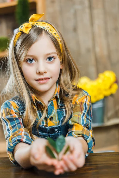 Selektiver Fokus des niedlichen Kindes, das grüne Blätter in den Händen hält — Stockfoto