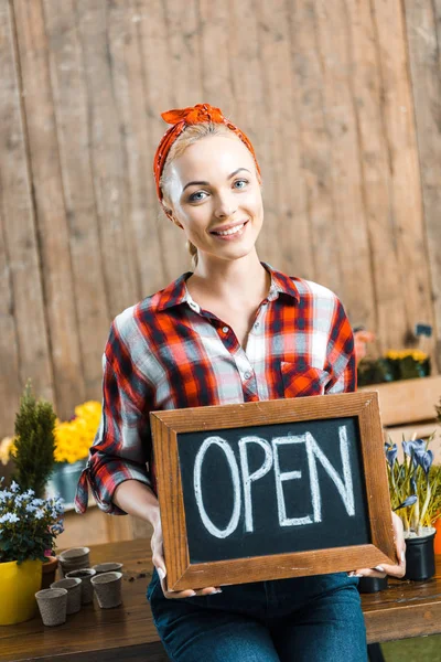 Mulher feliz segurando quadro com letras abertas — Fotografia de Stock