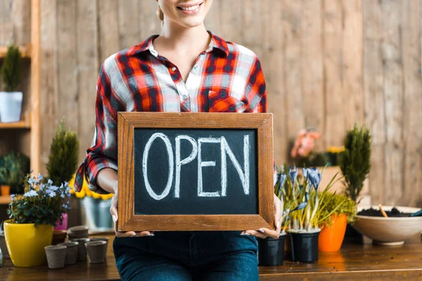 Vista recortada de la mujer sosteniendo pizarra con letras abiertas - foto de stock