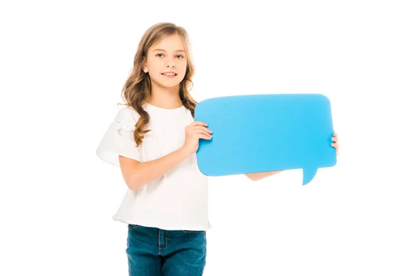 Adorable sonriente niño sosteniendo azul habla burbuja aislado en blanco - foto de stock