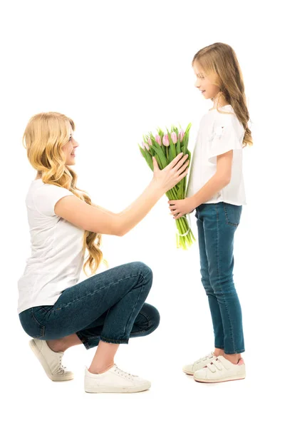 Hockt und nimmt einen schönen Strauß Tulpen von Tochter isoliert auf weißem Grund — Stockfoto