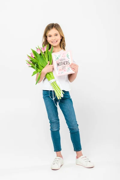 Прелестный ребенок с букетом розовых тюльпанов и поздравительной открыткой на белом фоне — стоковое фото