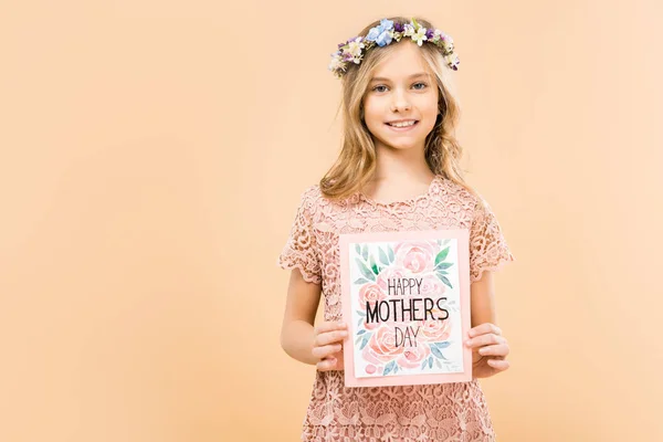 Entzückendes lächelndes Kind in zartem Spitzenkleid und Blumenkranz mit Glückwunschkarte zum Muttertag auf gelbem Hintergrund — Stockfoto