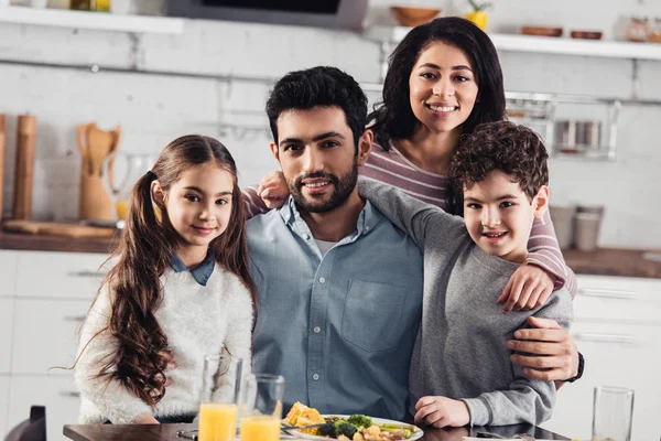 Cheerful hispanic family smiling while looking at camera at home — Stock Photo