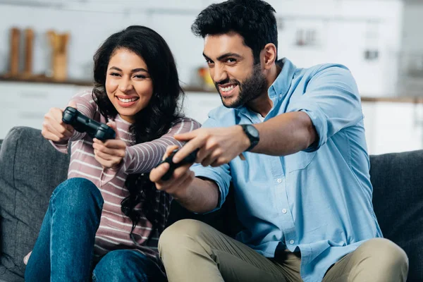 Fröhliche hispanische Familie hält Steuerknüppel in der Hand und spielt zu Hause Videospiel — Stockfoto