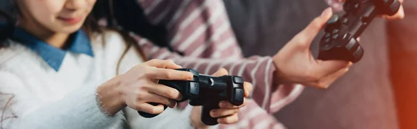 Vista ritagliata del bambino che gioca al videogioco con la madre a casa — Foto stock