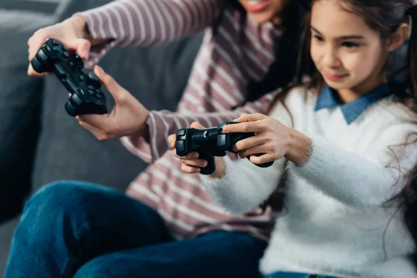 Vista ritagliata di carino bambino latino giocare al videogioco con la madre a casa — Foto stock