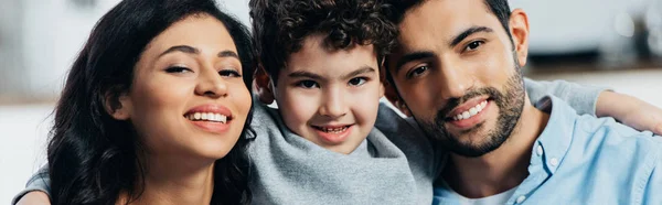 Glückliche lateinische Familie lächelt, während sie zu Hause in die Kamera schaut — Stockfoto
