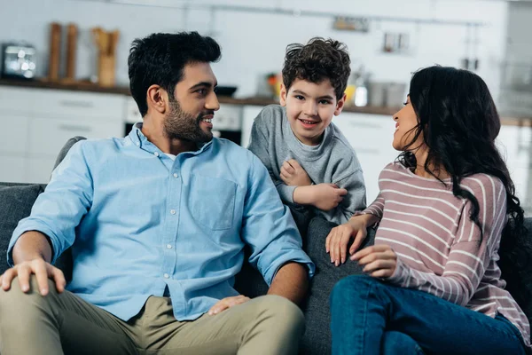 Happy latin husband and wife looking at cute son at home — Stock Photo