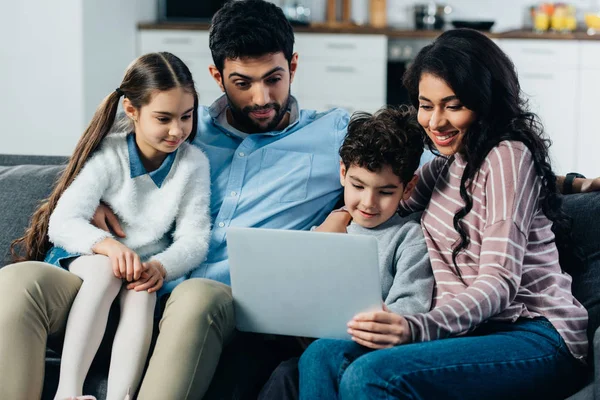 Famiglia ispanica felice guardando il computer portatile a casa — Foto stock