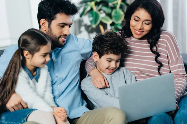 Alegre família hispânica olhando para laptop em casa — Fotografia de Stock