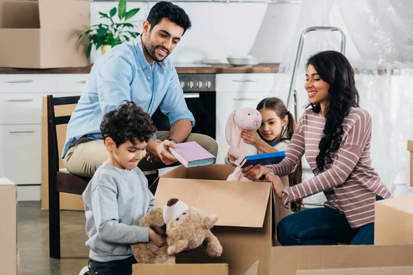 Feliz família latina desempacotando caixas em nova casa — Fotografia de Stock