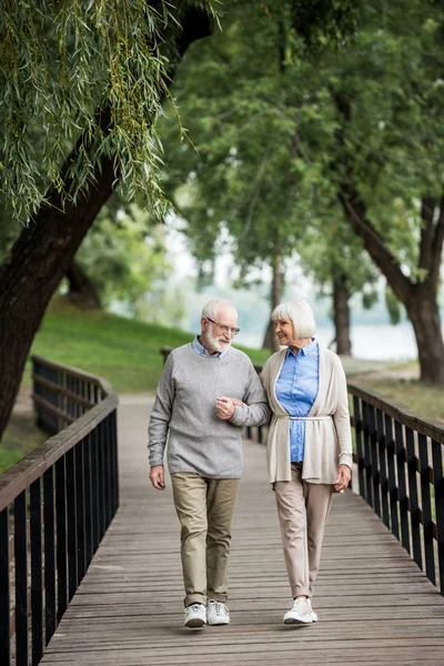 Милая пожилая пара с удовольствием гуляет в парке — стоковое фото