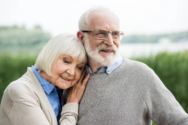 Glückliche stilvolle Seniorin lehnt sich an die Schulter ihres Mannes — Stockfoto