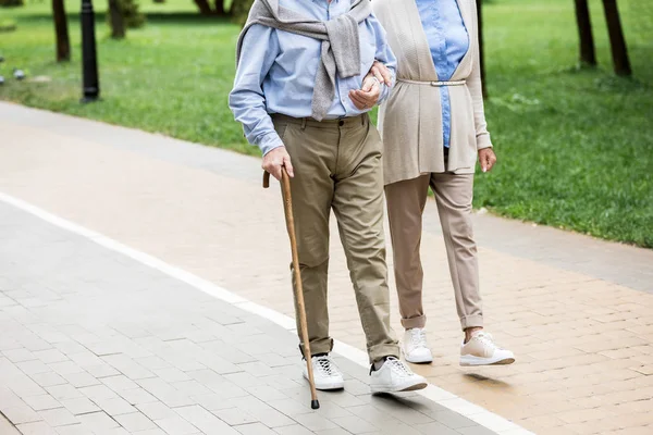 Vista recortada de pareja mayor caminando en el parque - foto de stock