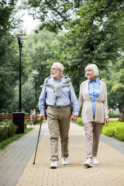Felice sorridente coppia anziana a piedi nel parco — Foto stock